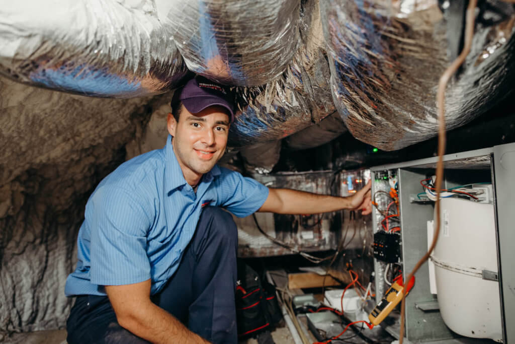 hvac technician inspecting a furnace