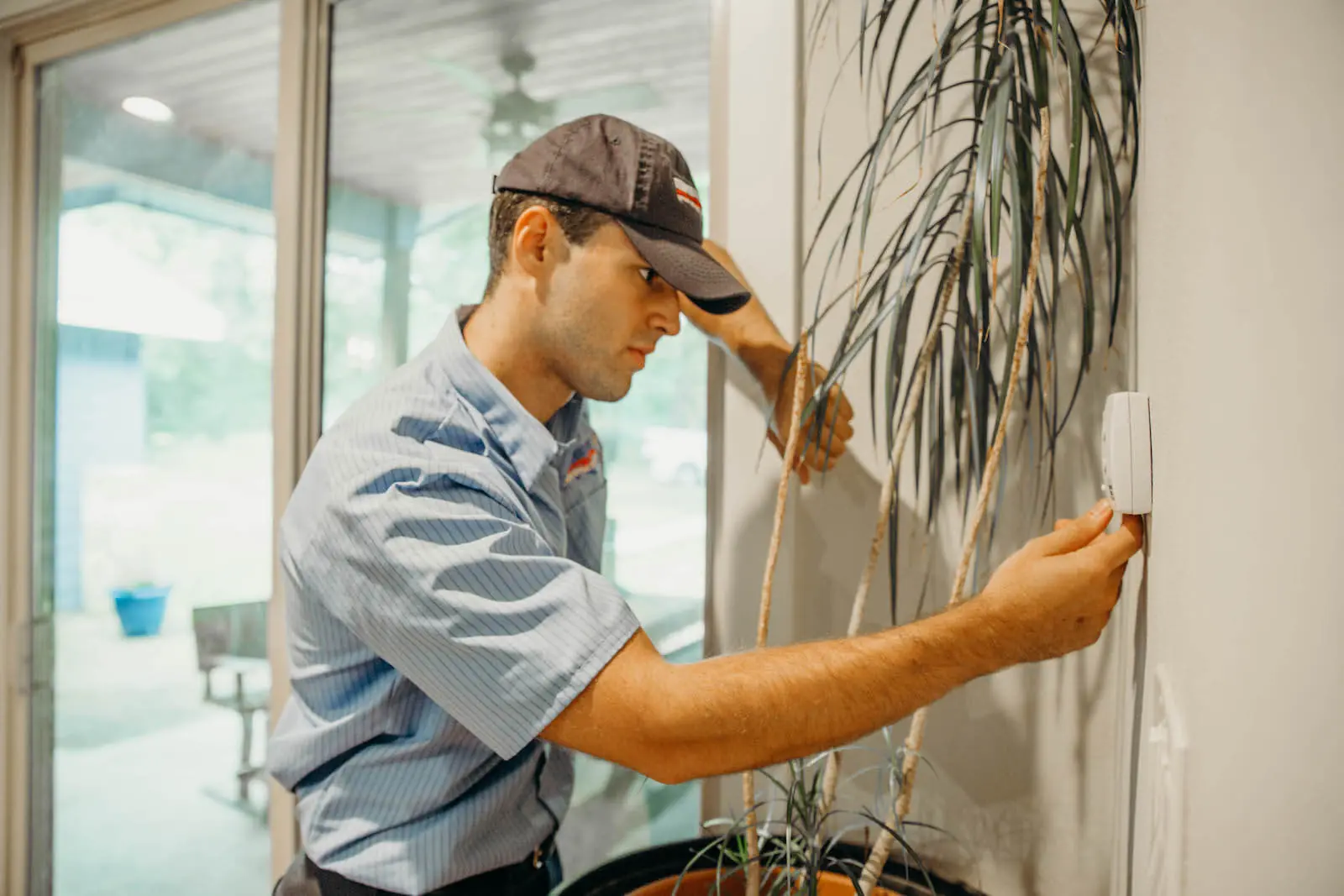 hvac technician testing a thermostat during heating tune up