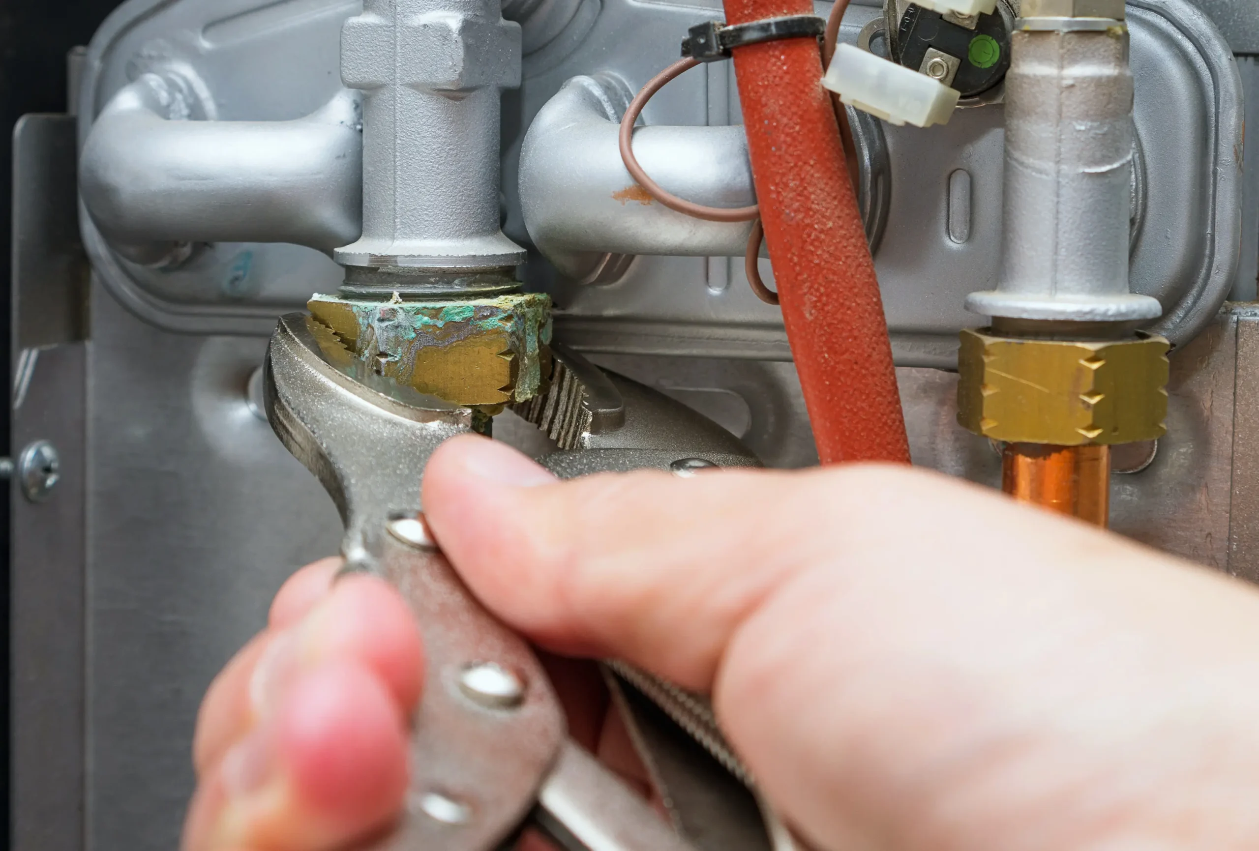 Columbus heating repair technician using wrench to fix broken furnace.